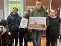 grupa uczniów prezentuje nagrody o dyplom