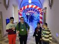 13.uczniowie pozują do zdjęcia w korytarzu zamku w tle świąteczna dekoracja