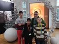 17.uczniowie pozują do zdjęcia w jednej z sal zamku w tle dekoracja świąteczna w kolorze białym