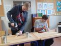 1. Jeden uczeń stoi przy ławce nawierca otwory wiertarką w metalowej puszce. Drugi uczeń majsterkuje z metalowymi elementami 