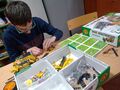 10. Uczeń siedzi przy szkolnej ławce skręca według instrukcji model pojazdu z metalowych elementów 