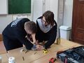 2. Uczeń nawierca otwory wiertarką w metalowej puszce asekuruje go nauczyciel 