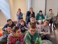 Uczniowie siedzą w Muzeum i słuchają opowieści o zwyczajach wielkanocnych