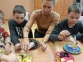 5. Uczniowie z pomocą nauczyciela ozdabiają choinkę 