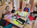 1. Uczniowie siedzą przy stole na którym znajdują się produkty do wykonania pizzy 