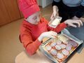 uczeń kładzie szynkę na pizzę
