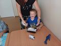 uczeń siedzi przy stoliku w klasie i się śmieje