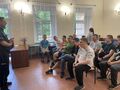 3 Uczniowie i nauczyciele siedzą na krzesłach w klasie przed nimi stoi policjantjpg