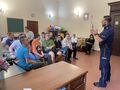 4 Uczniowie i nauczyciele siedzą na krzesłach w klasie przed nimi stoi policjantjpg