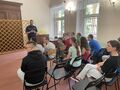 6 Uczniowie i nauczyciele siedzą na krzesłach w klasie przed nimi stoi policjantjpg