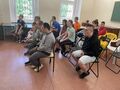 9 Uczniowie i nauczyciele siedzą na krzesłach w klasie