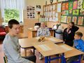 8. Uczniowie czekają na degustację szaszłyków, siedzą w ławkach przy stole