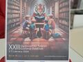 Plakat Ogólnopolski Tydzień Czytania Dzieciom z napisami porozmawiajmy o książkach tygrysie, plakat przedstawia tygrysa który czyta dzieciom