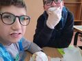dwóch chłopców je pączki przy stole