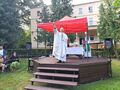 7. kapłani odprawiają mszę św. stoją na scenie za nimi znajduje się ołtarz