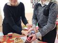 5. Dziewczynka z pomocą pani nalewa szampana do kubeczka 