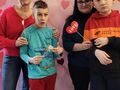 13. Uczniowie z dwoma paniami pozują do zdjęcia na tle walentynkowej ścianki 
