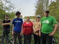 grupa wychowanków stoi z rowerami obok stawu trafary