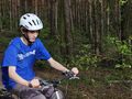 wychowanek jedzie na rowerze w lesie