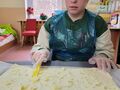 2. Dziewczynka smaruje ciasto francuskie masłem czosnkowym 