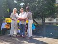 Panie Dyrektor wręczają uczniowi prezent na pożegnanie na scenie