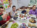 Uczniowie siedzą przy stole urodzinowym jedzą smakołyki