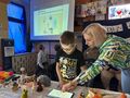 Nauczycielka pomaga uczniowi przy pracy z tabletem