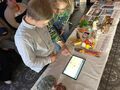 Nauczycielka tłumaczy uczniowi zadanie na tablecie