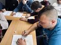 2. Uczniowie siedzą przy stoliku rozwiązują krzyżówkę w tle nauczycielka 