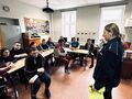 6. Sala koputerowa uczniowie siedzą w ławkach przed nimi stoi policjantka 