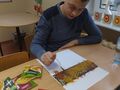uczeń posypuje kartkę przyprawami