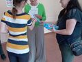 uczennica odebrała nagrodę za udział w konkursie na szkolnym korytarzu