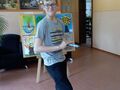 uczeń odebrał nagrodę za udział w konkursie na szkolnym korytarzu