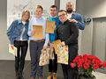 6. Trzej uczniowie wraz nauczycielami stoją i trzymają dylomy 