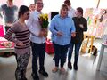 Zdjęcie ukazuje uczniów oraz nauczycielki którzy znajdują się w bibliotece. Chłopiec trzyma w rękach żółte tulipany 