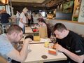 uczniowie jedzą posiłęk w restauracji