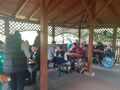 Uczniowie siedzą przy stole pod grzybkiem 