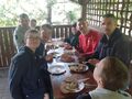 Uczniowie siedzą przystole pod grzybkiem 
