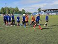 zawodnicy obu drużyn wychodzą na boisko