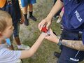 Pani policjantka robi pieczątki na dłoniach uczniajpg