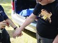 pani policjantka robi pieczątki na dłoniach ucznia z tyłu stoi radiowóz
