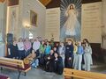 o.Walenty nauczyciele i starsi uczniowie pozują do zdjęcia w kościele w tle duży obraz Jezusa Miłosiernego