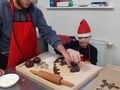 Chłopcy wykrawają ciasto piernikowe foremkami 