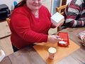 uczennica siedzi przy stole w pracowni i maluje skrzynkę