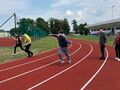 uczniowie biegną dookoła po bieżni stadionu