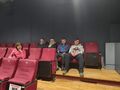 6. Uczniowie z nauczycielem siedzą w sali kinowej 
