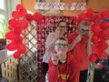 6. Uczniowie razem z wychowawcą pozuja na tle fotościanki walentynkowej 