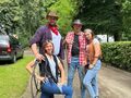 dwóch panów i dwie panie pozują do zdjęcia grupowego w parku za nimi stoi samochód