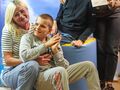 11. młodsi uczniowie i nauczyciele pozują do zdjęcia na niebiańskim tle