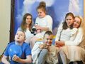 8. młodsi uczniowie i nauczyciele pozują do zdjęcia na niebiańskim tle